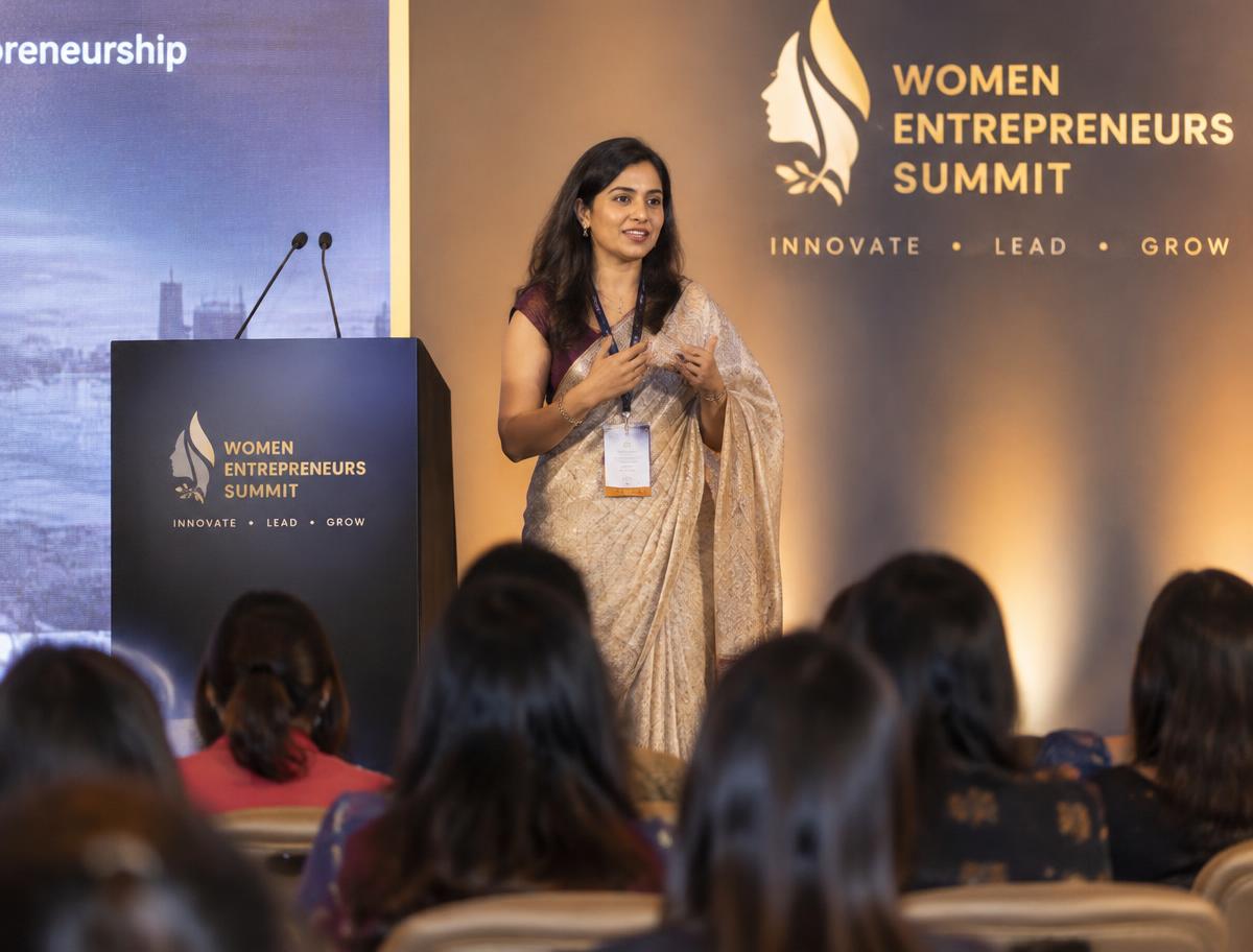 A woman speaking on stage at a women entrepreneurs summit